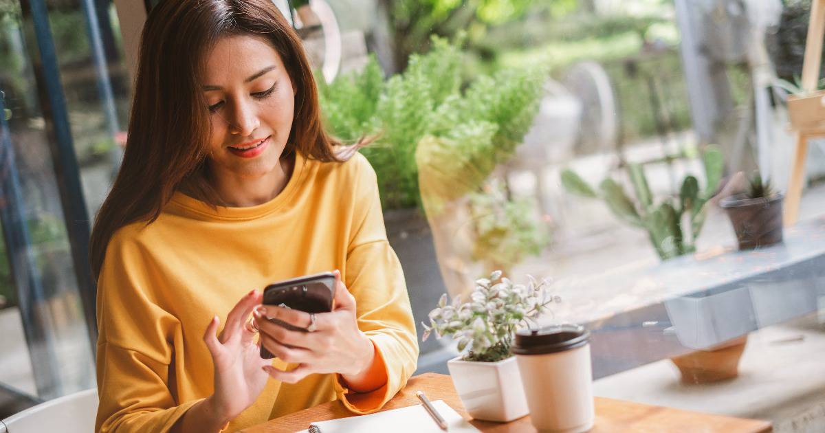 woman at cafe looking at Christian ebooks on her phone