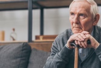elderly man on couch listening to worship songs about suffering