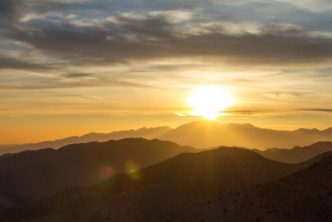 sun rising over desert mountains, blog header for Easter Bible verses post